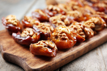 Walnut, date fruit on wooden table, close-up