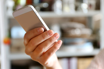 Woman holding smartphone indoors