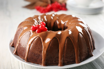 Chocolate cake with snow ball tree berries on plate on a table