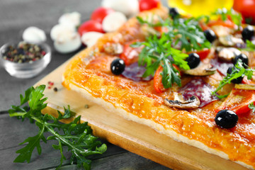 Rectangle delicious pizza and vegetables on the table, close-up