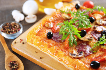 Rectangle delicious pizza and vegetables on the table, close-up