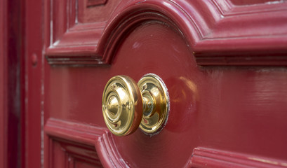 Shiny Brass Doorknob on Red Wooden Entry Door