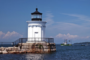 Fototapeta na wymiar Portland Breakwater Lighthouse Guides Fishing Boat Home in Maine