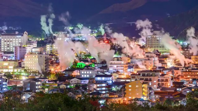 Beppu, Japan cityscape with hot spring bath houses and rising steam.