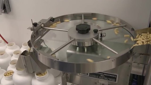 Handheld pan shot of a capsule sorting machine.