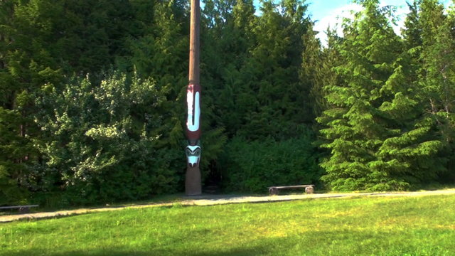 Panning shot of a house and totem poles in Totem Bight State Park