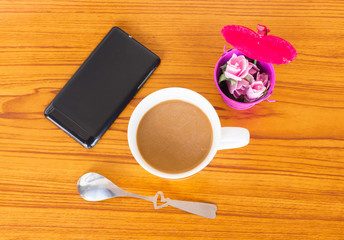 Cup of coffee, cellphone on table, Top view