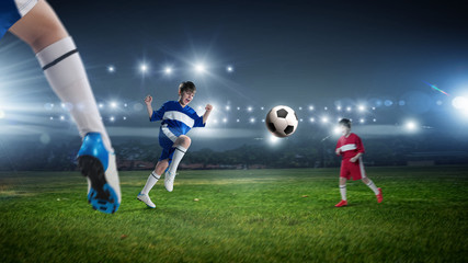 Obraz na płótnie Canvas Kids play soccer on stadium 