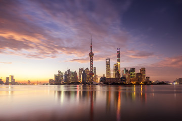 Obraz premium waterfront cityscape and illuminated skyline at dawn