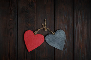 Fototapeta na wymiar Wooden hearts on dark wood background
