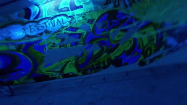 Blue alleyway with graffiti appearing and disappearing.