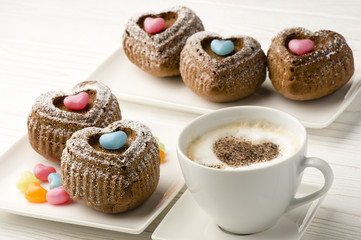 Chocolate muffins in the shape of heart on the white plate.