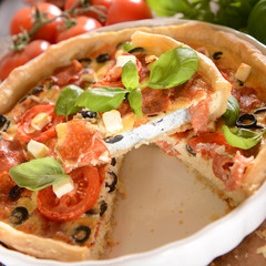 Tart (Quiche) with tomatoes, basil, salami, black olives and che