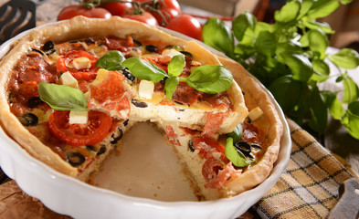 Tart (Quiche) with tomatoes, basil, salami, black olives and che