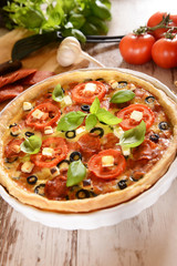 Tart (Quiche) with tomatoes, basil, salami, black olives and che