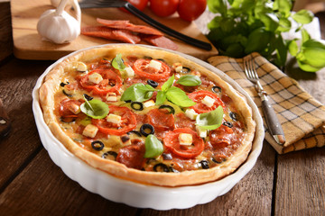 Tart (Quiche) with tomatoes, basil, salami, black olives and che