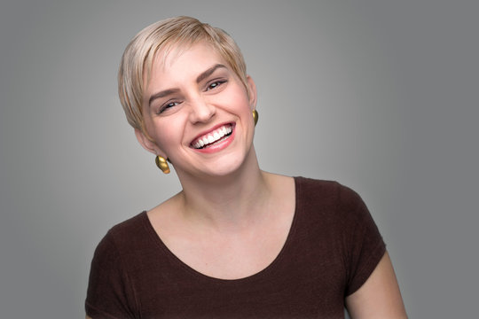 Adorable laughing lady head shot short pixie haircut modern style gray background