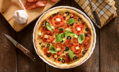 Tart (Quiche) with tomatoes, basil, salami, black olives and che