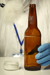 Scientist developing fingerprints on beer bottle