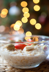 Healthy Homemade Oatmeal in a transparent plate with feta and olives for Breakfast in the background Christmas tree 