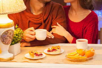 The  happy young couple with cups of tea 