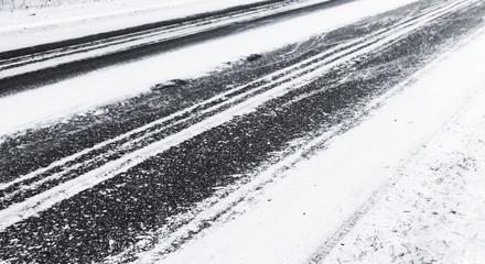 Black asphalt pavement under fresh snow layer