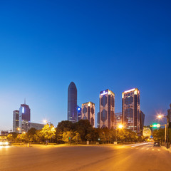 traffic on road and modern building in clear sky at dawn