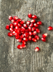 pomegranate seeds on wooden surface