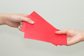 Obraz premium woman hand giving red envelop containing money, during Chinese N