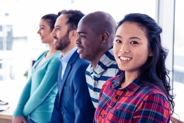Portrait of young businesswoman standing with colleagues