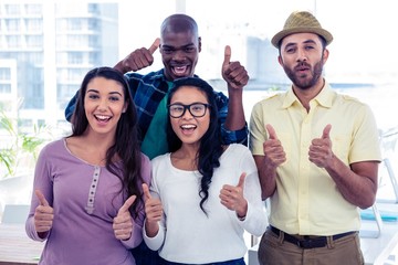 Portrait of creative business people with thumbs up