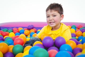 Fototapeta na wymiar Cute smiling boy in sponge ball pool