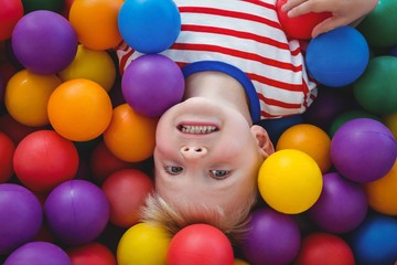 Fototapeta na wymiar Cute smiling boy in sponge ball pool