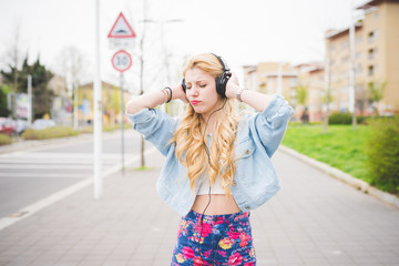 Knee figure of young handsome caucasian blonde girl listening mu