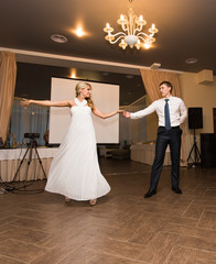 beautiful caucasian couple just married and dancing their first dance