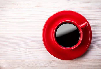 Red coffee cup on light wooden table
