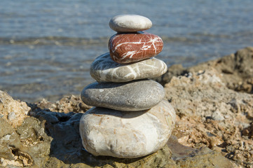 Fototapeta na wymiar Pyramid of pebbles on the sea beach