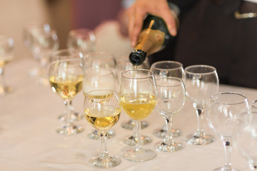 Pouring champagne in flutes standing on table