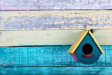 colorful wooden bird house with grunge background.