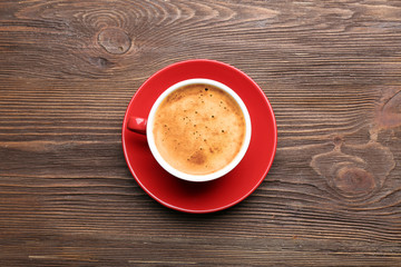 Cup of coffee on wooden table, top view