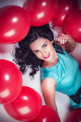 Happy young woman with red latex balloons