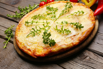 Tasty pizza decorated with herbs and vegetables on wooden background, close up