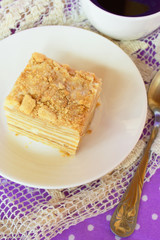 Cake Napoleon on a white plate, a Cup of coffee, good morning