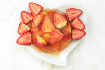 gelatin dessert and fresh strawberries on white marble