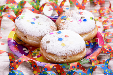 Faschingskrapfen zum Karneval mit Luftschlangen und Konfetti