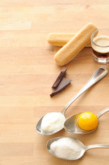 Ingredienti per cheesecake, su tavolo di legno, uova, yogurt, zucchero, biscotti, cioccolato, scatto verticale, luce naturale