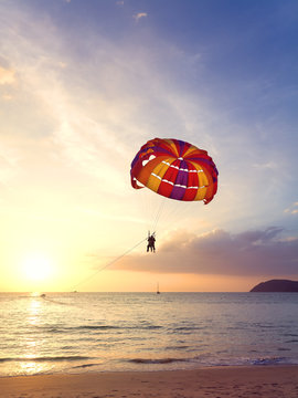 Parasailing at sunset, summer adventure concept.