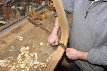 carpenter working with plane on wooden