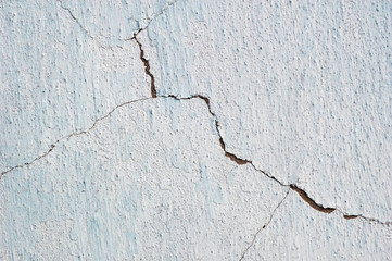 Abstract background cracked plaster surface painted white over blue