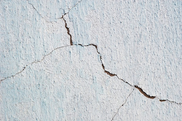 Obraz premium Abstract background cracked plaster surface painted white over blue